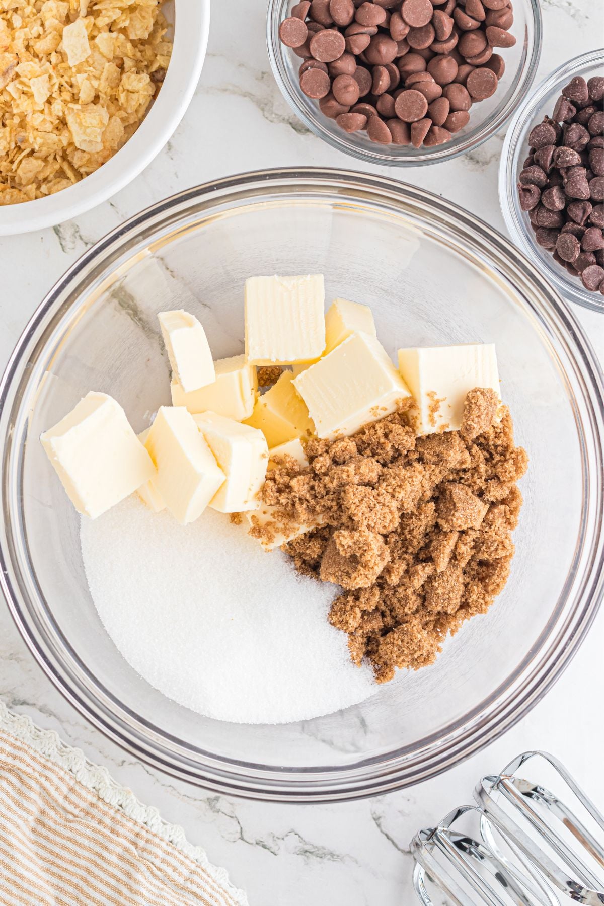 Brown sugar, white sugar, and cold butter in a mixing bowl.