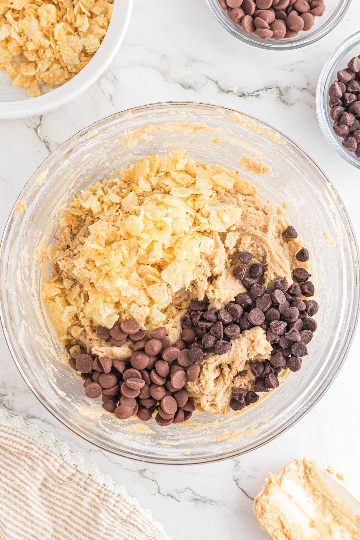 The crushed potato chips and chocolate chips added to the mixture.