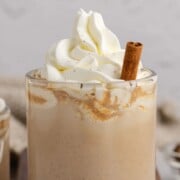 Pumpkin chai latte in a glass cup with whipped cream.