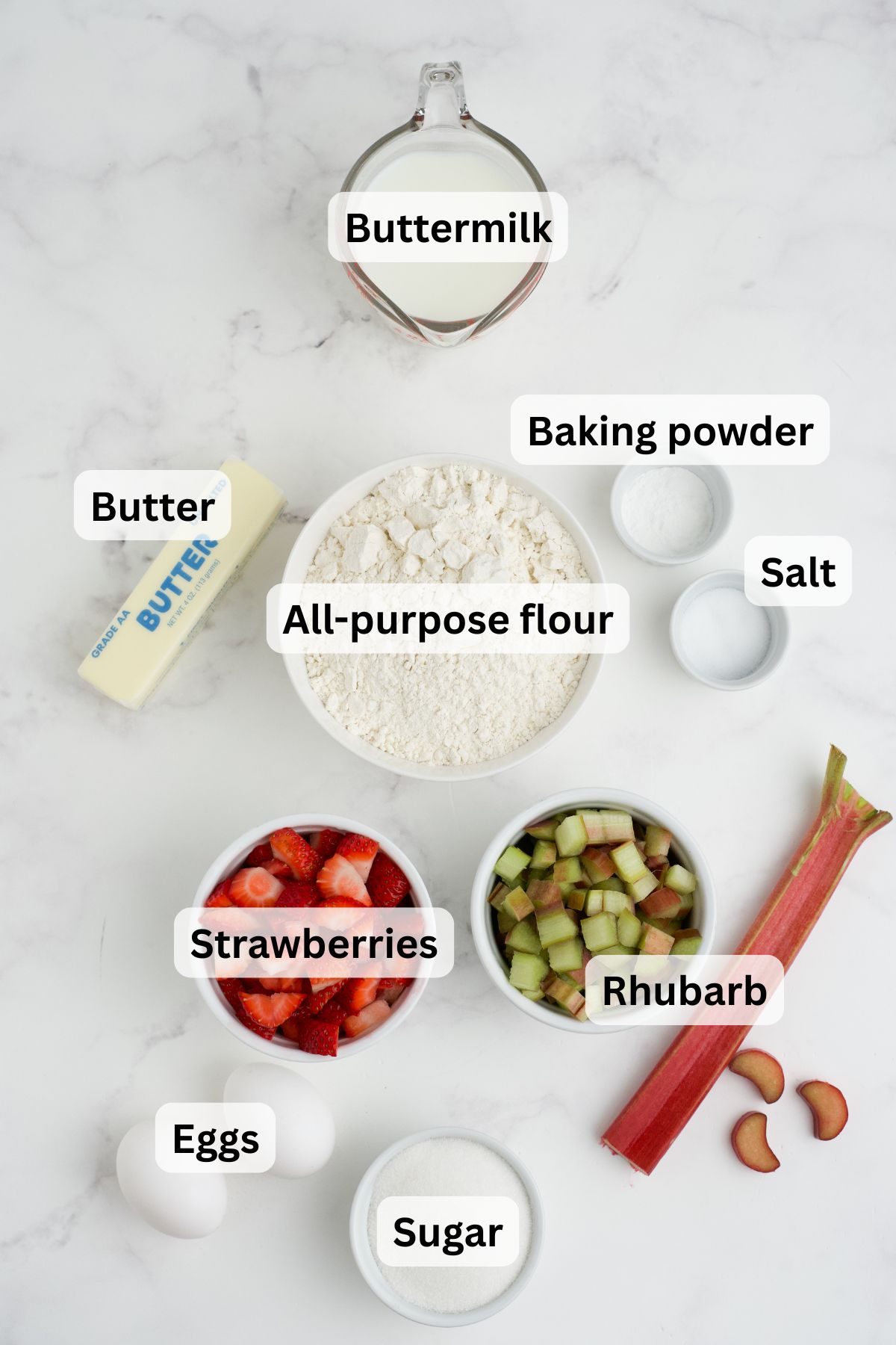 Ingredients to make these strawberry and rhubarb muffins on a table.