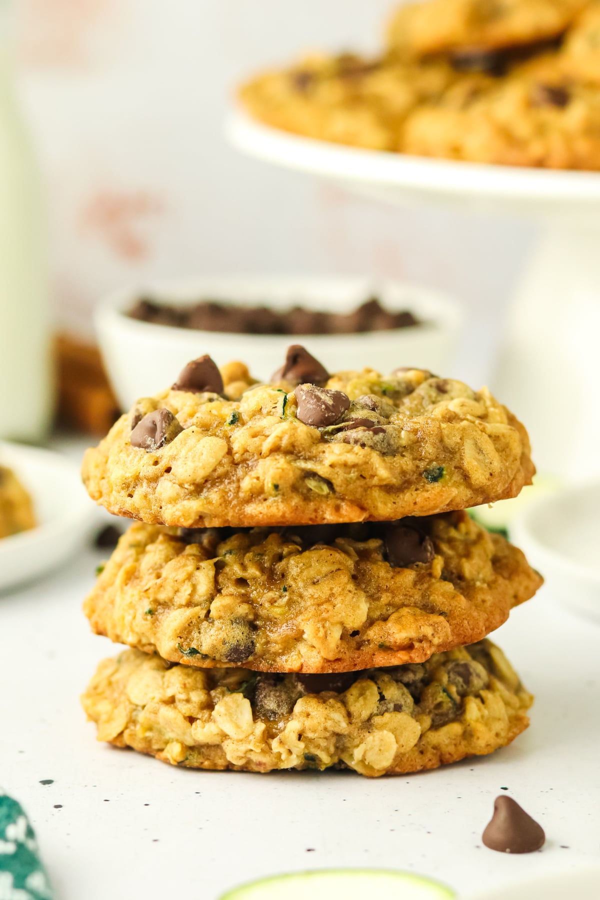 Chocolate chip cookies with zucchini stacked on a table.