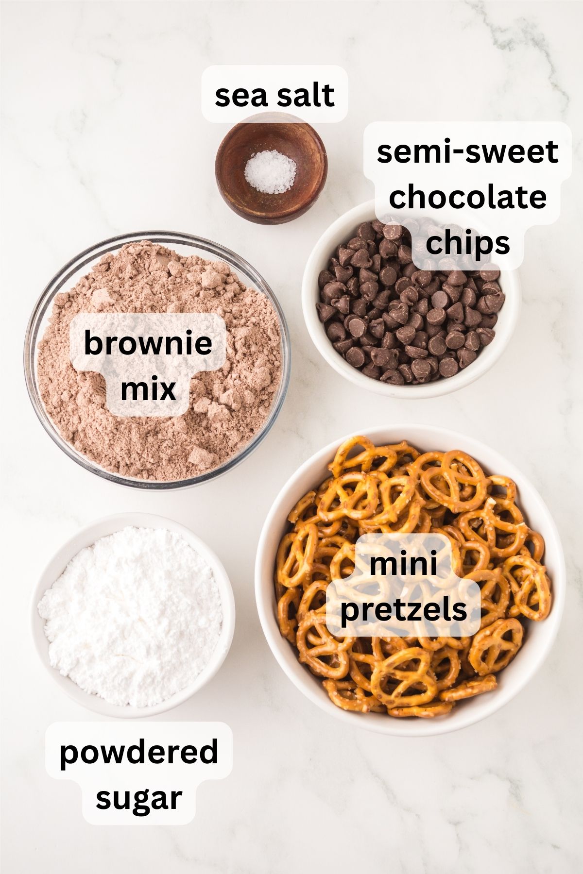 All of the ingredients needed to make brownie pretzels in bowls on a table.