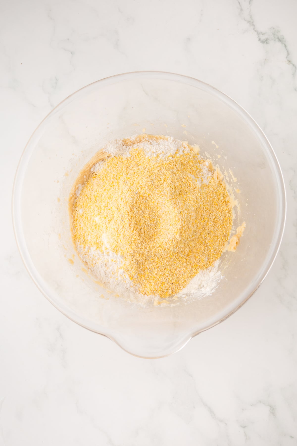 Flour, cornmeal, baking powder, and baking soda added to the mixing bowl.