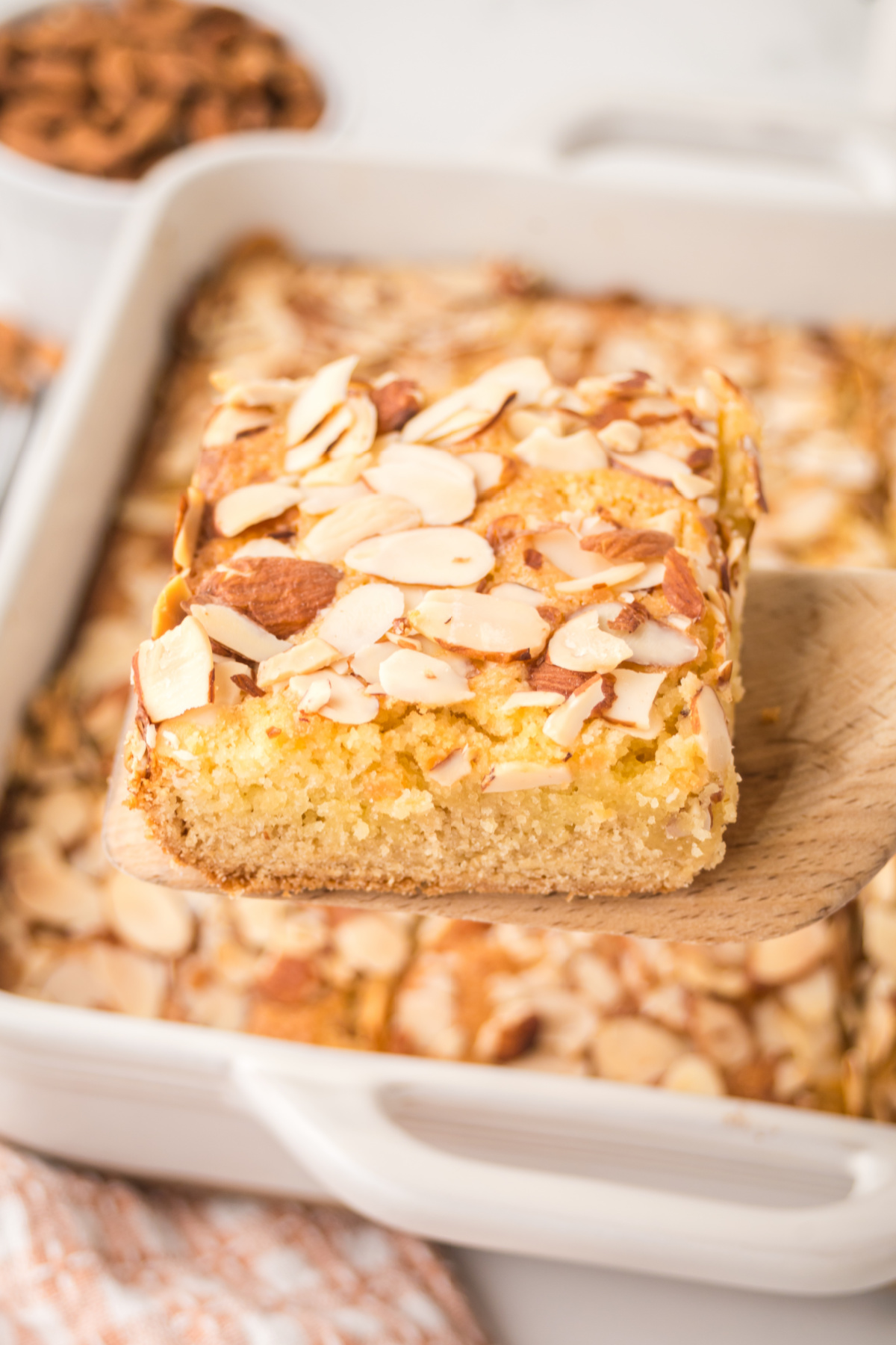 Almond cookie bar being held up with a spatula.