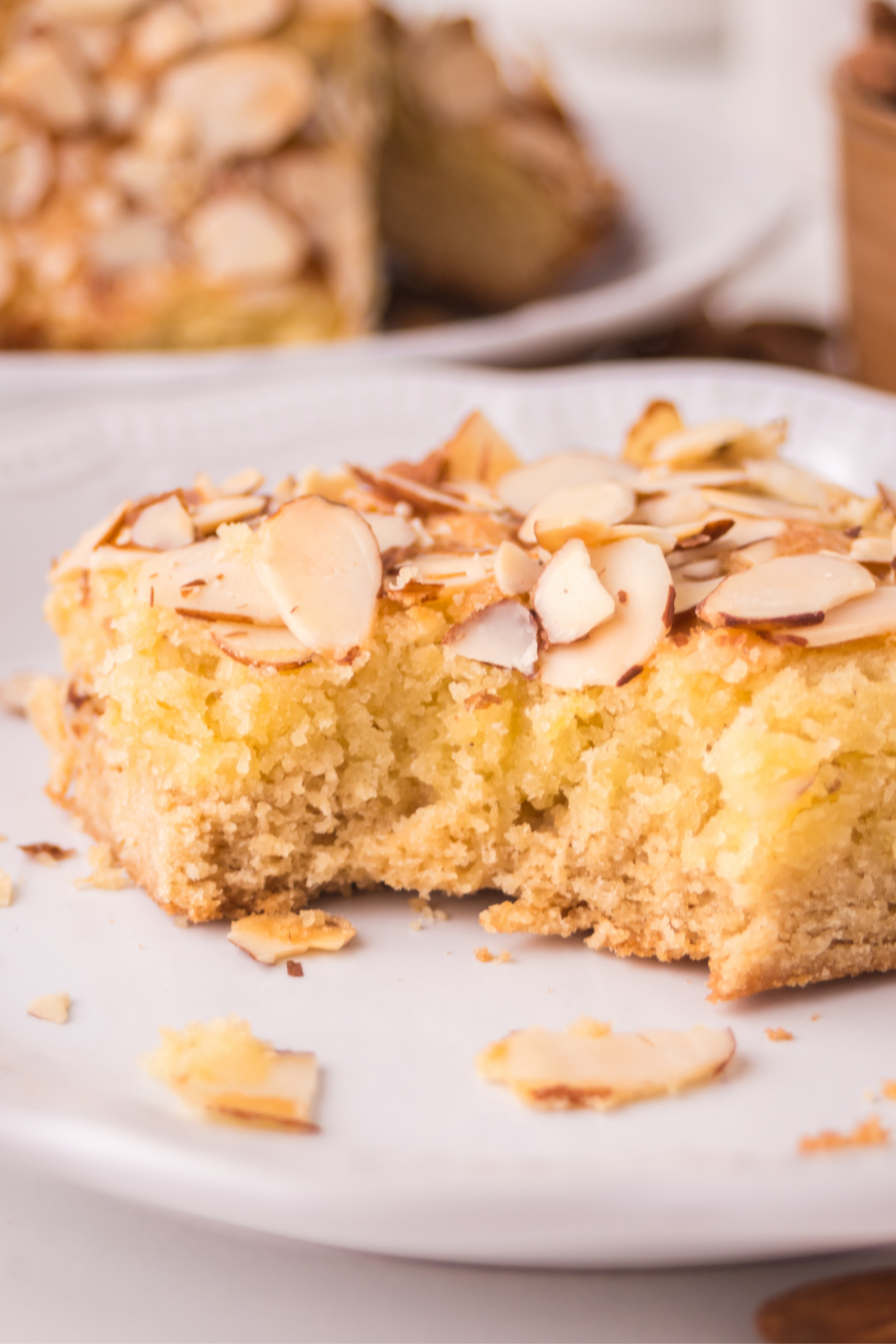 A bite taken from the cookie bar with almonds on top.