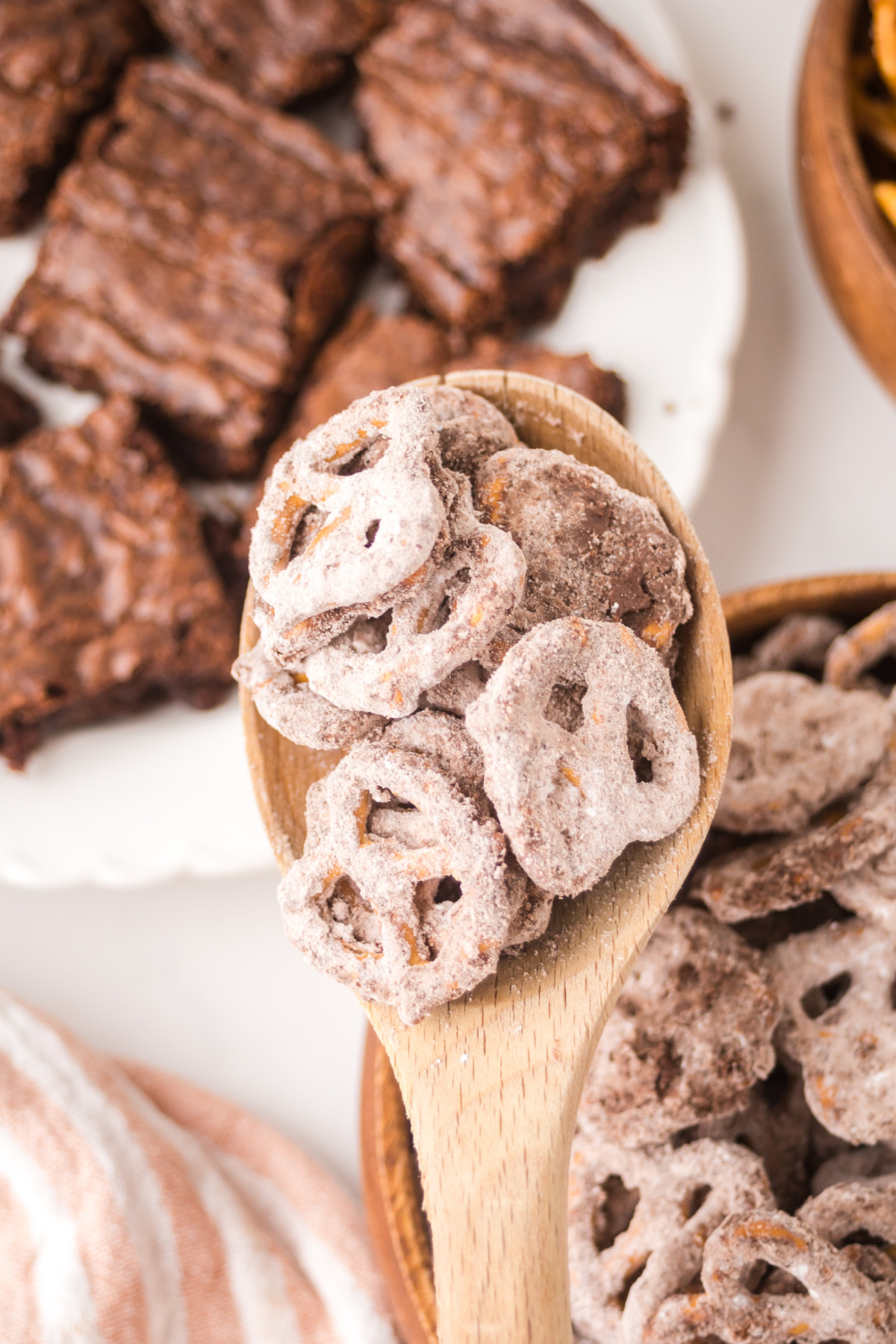 A wooden spoon full of Brownie Pretzels held in the air