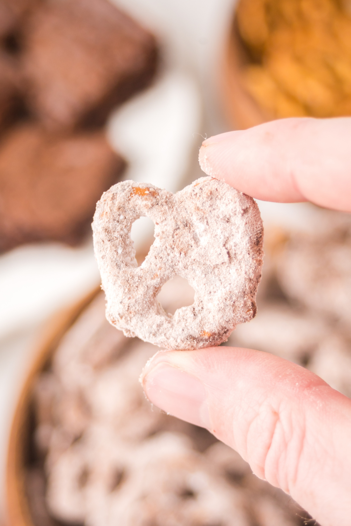 A single pretzel held in the air ready tp eat.