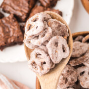A wooden spoon full of Brownie Pretzels held in the air