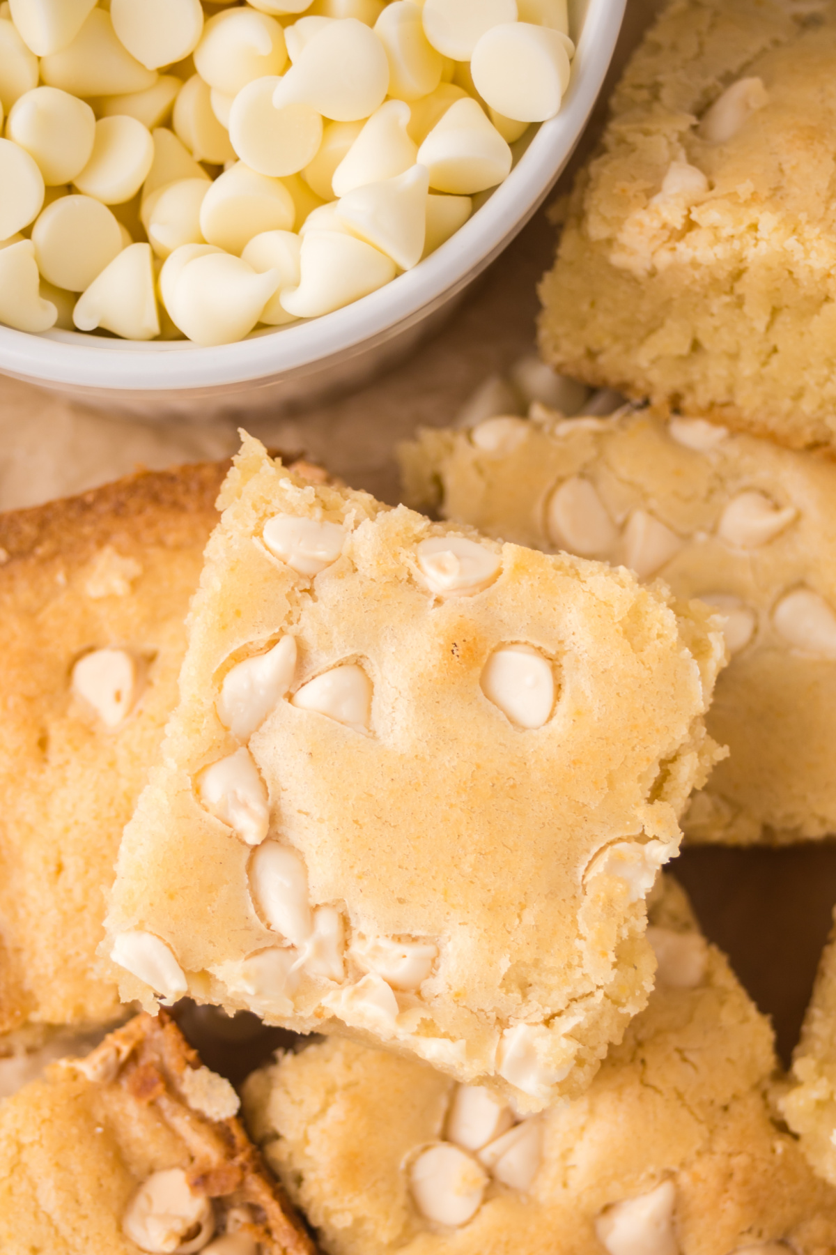 A white chocolate brownie slice on a pile of brownies.