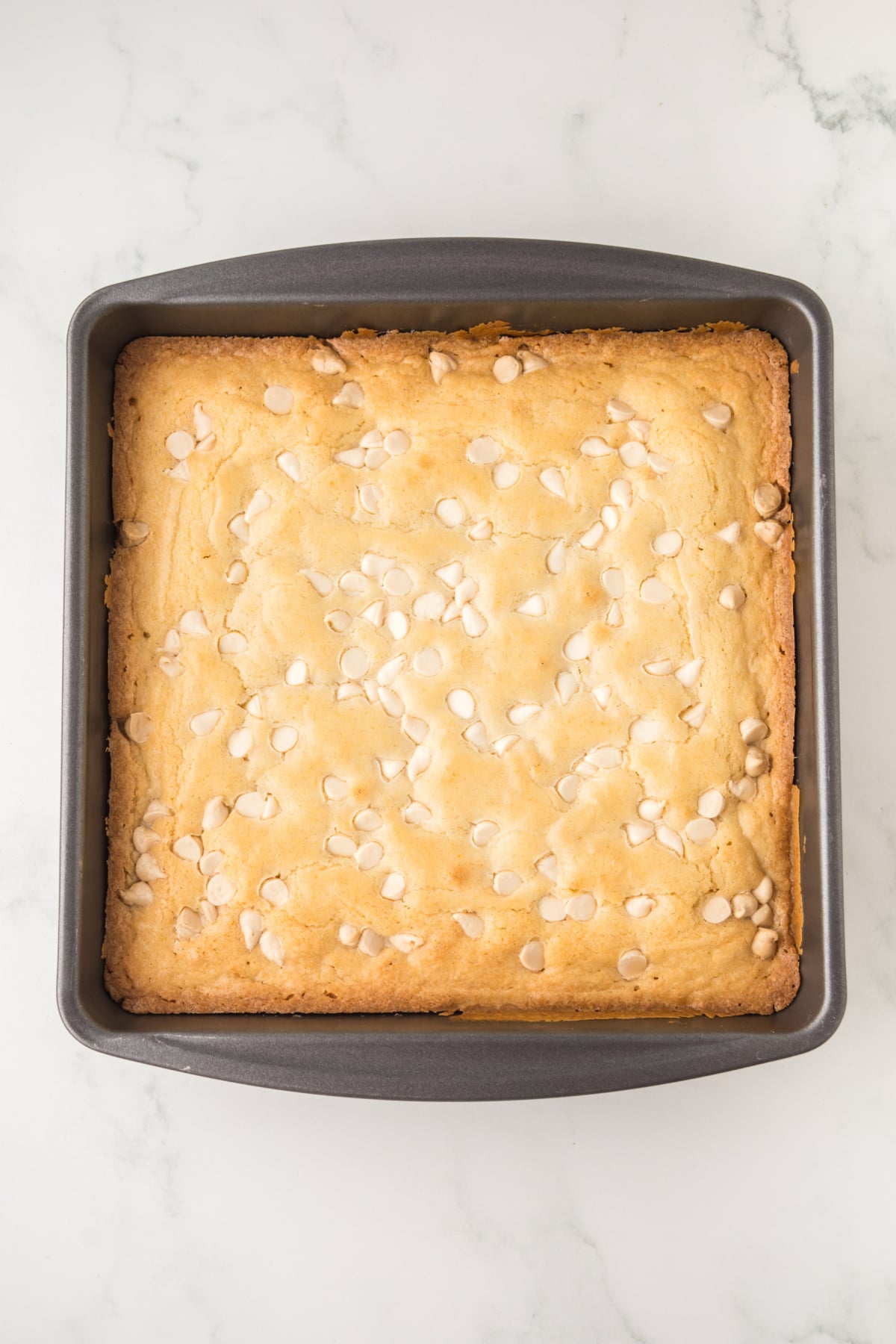 White brownies baked and cooling in a baking pan.