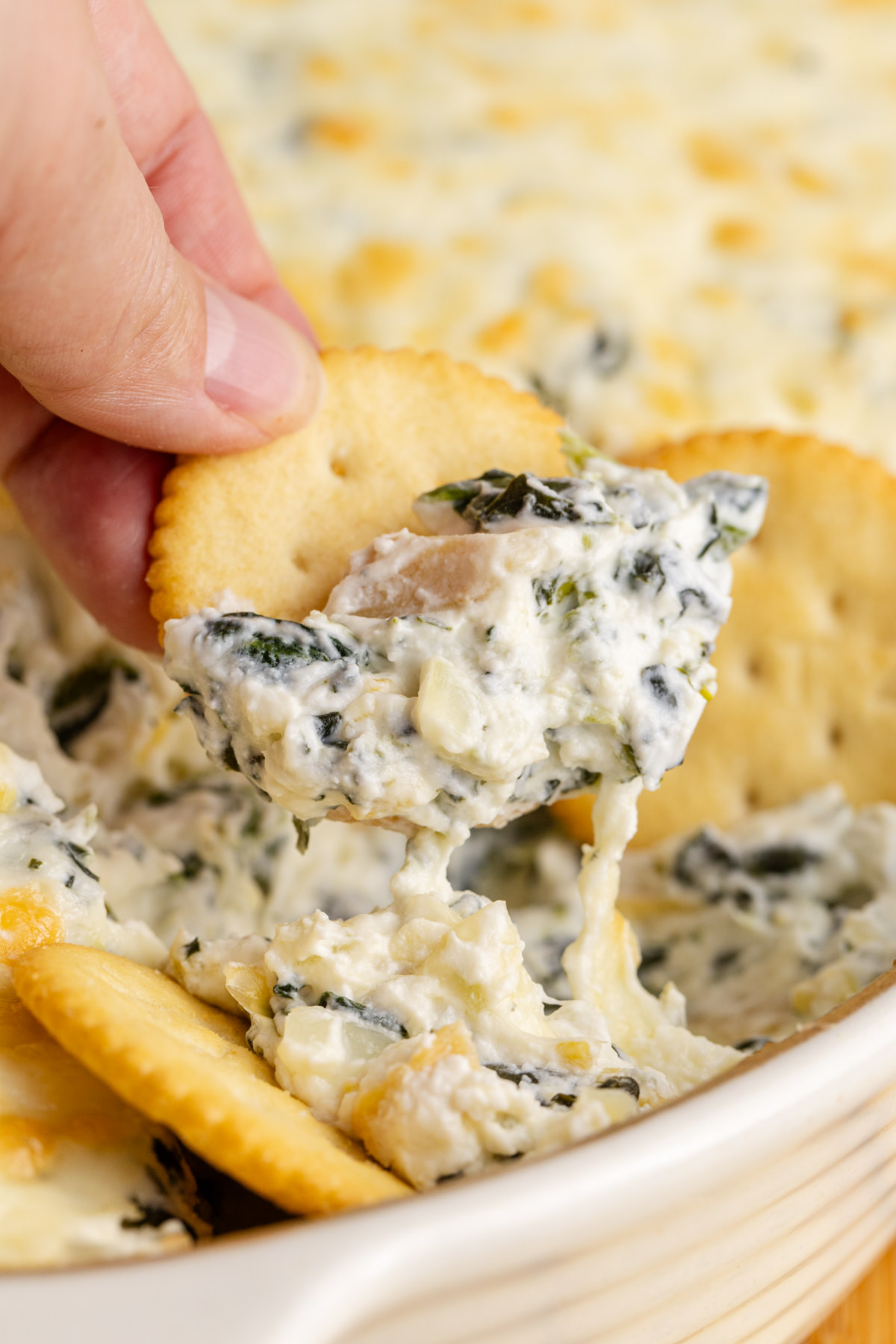 Dip being scooped out with a cracker.