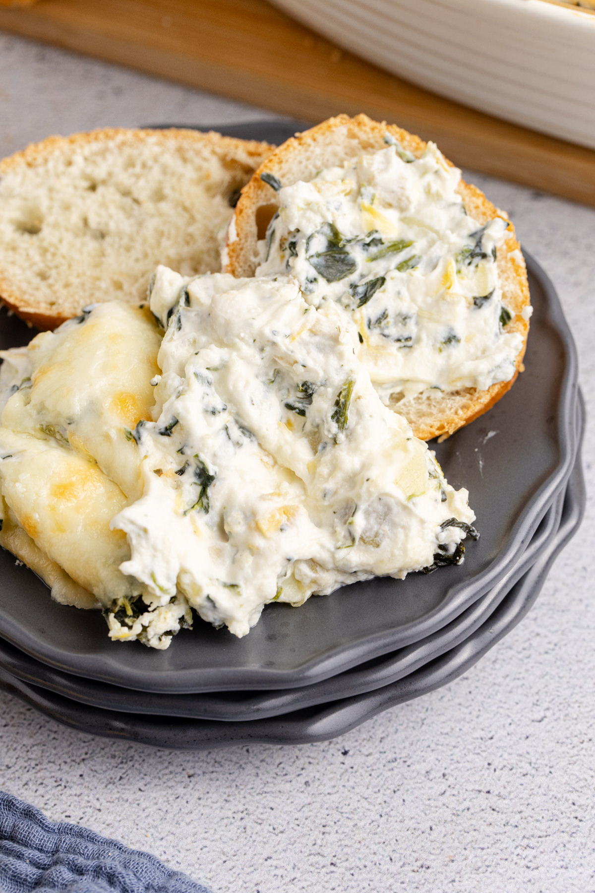 Some spinach dip on bread on a plate.