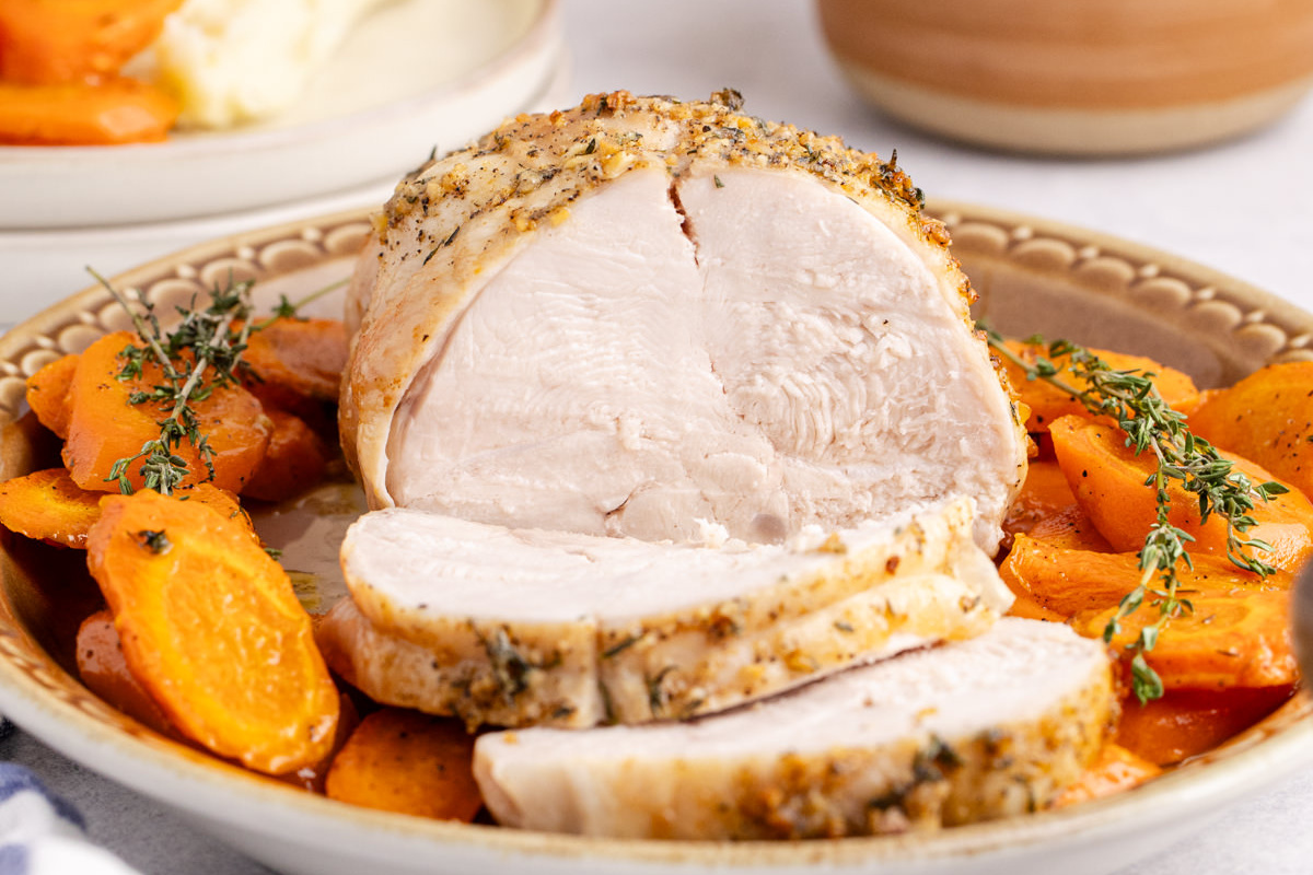 Boneless turkey breast recipe on a plate with carrots.