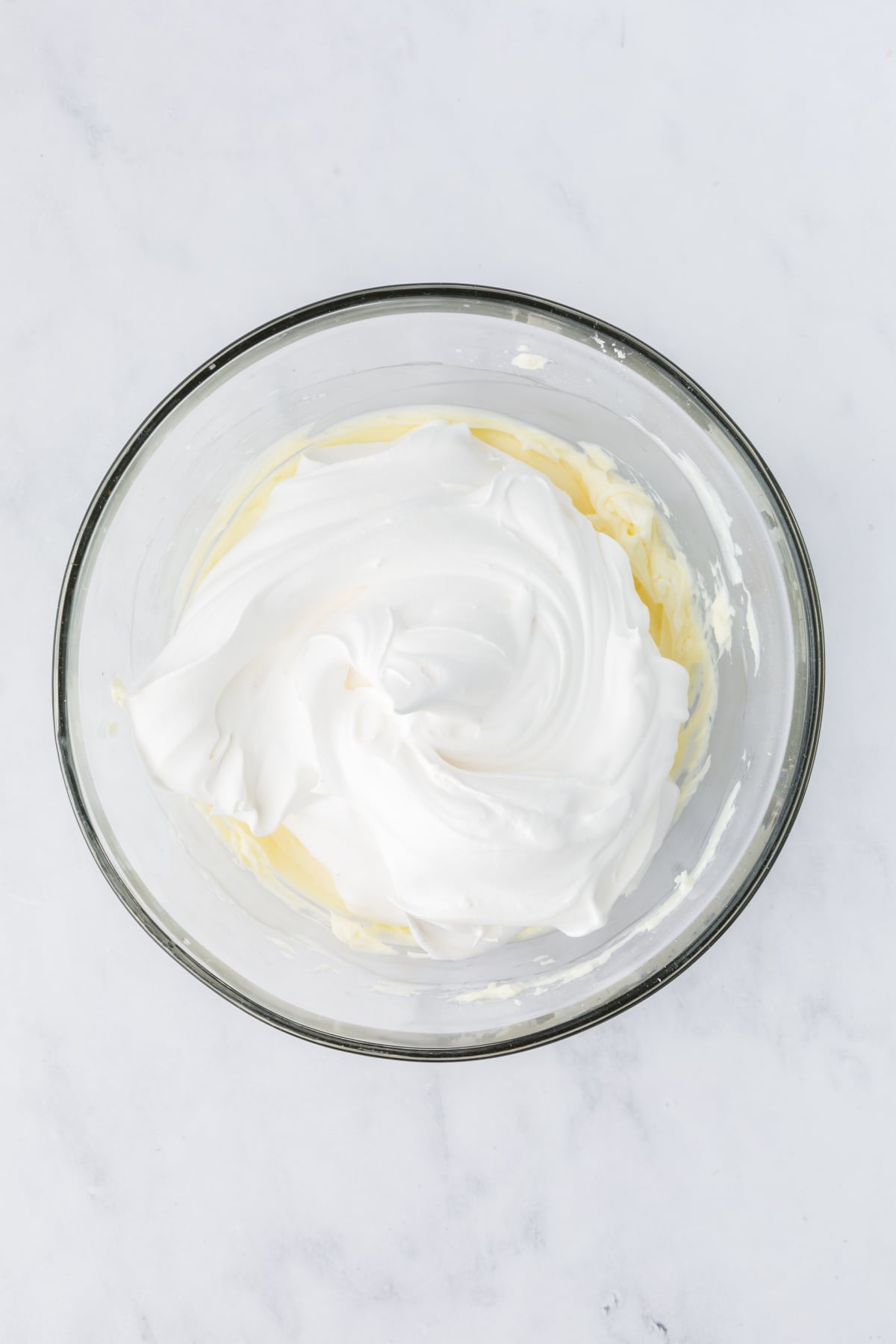 Cream cheese and powdered sugar beaten in a bowl.