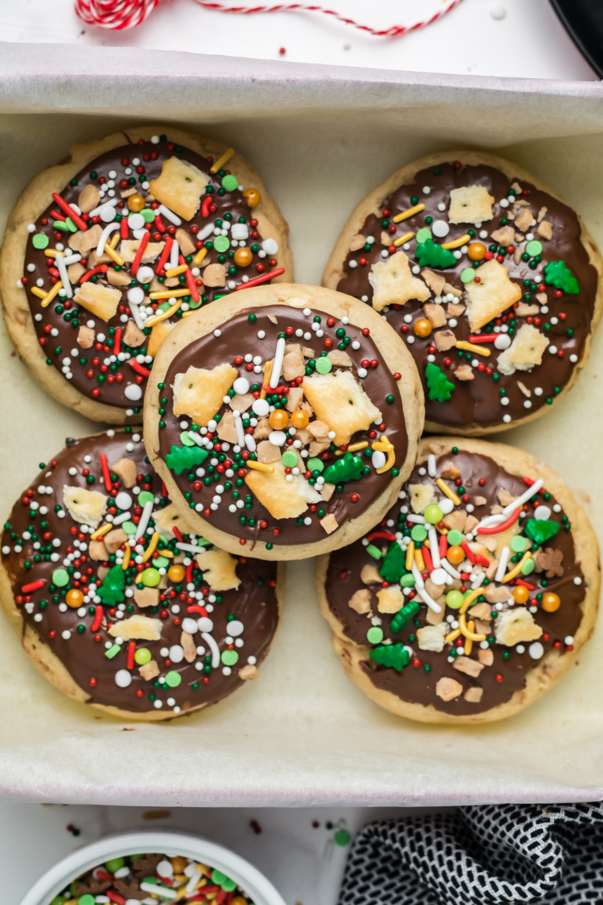 Cookies with chocolate, saltine crumbs, toffee bits, and sprinkles on top.