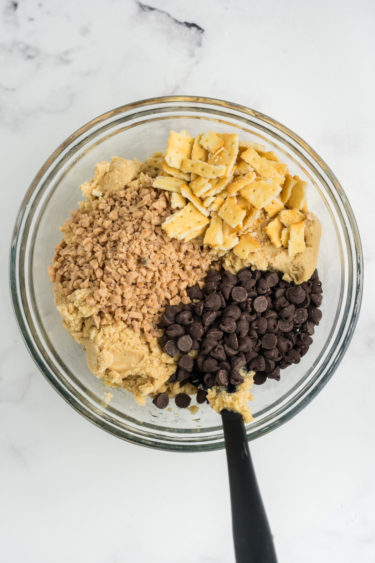 Crushed crackers, chocolate chips, and toffee bits folded into the mixture.