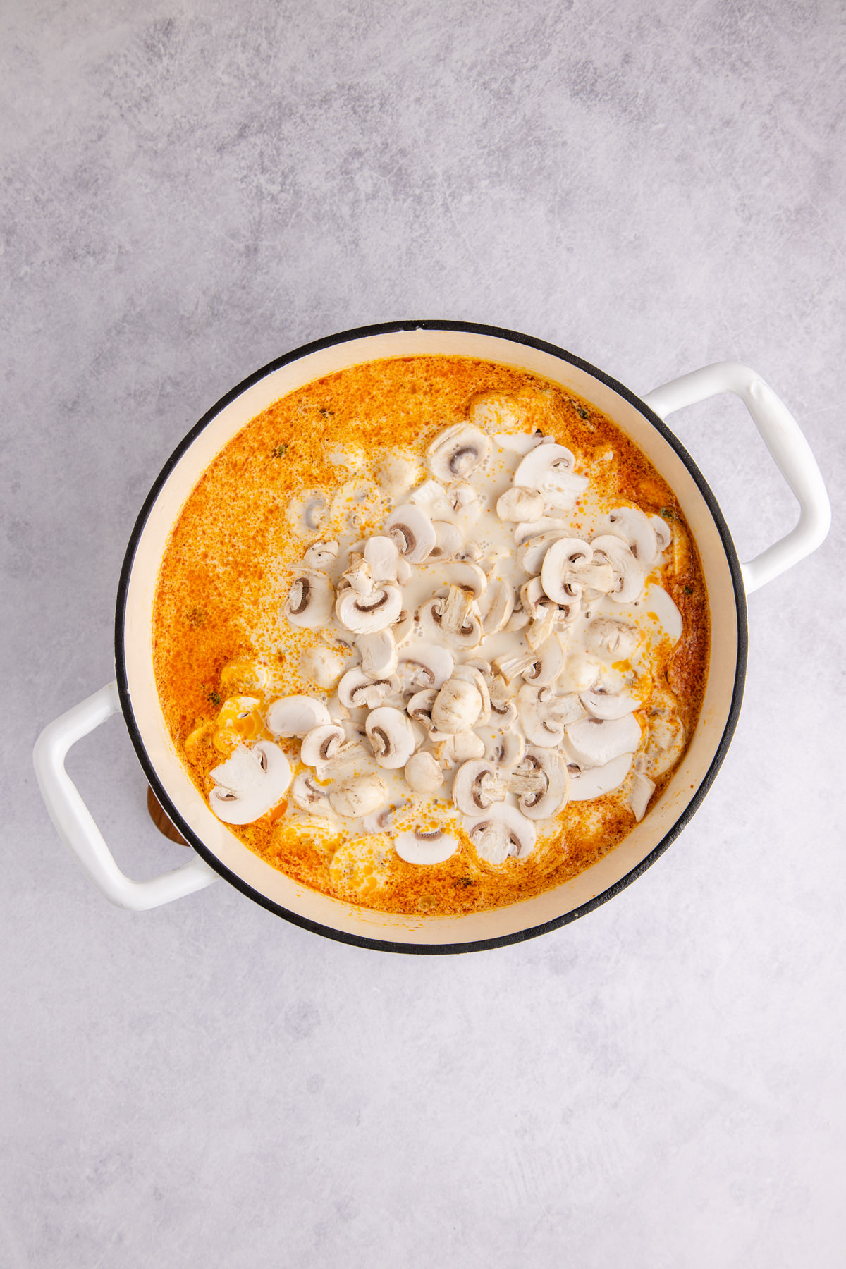 Broth, coconut milk, mushrooms and fish sauce added to the pot.