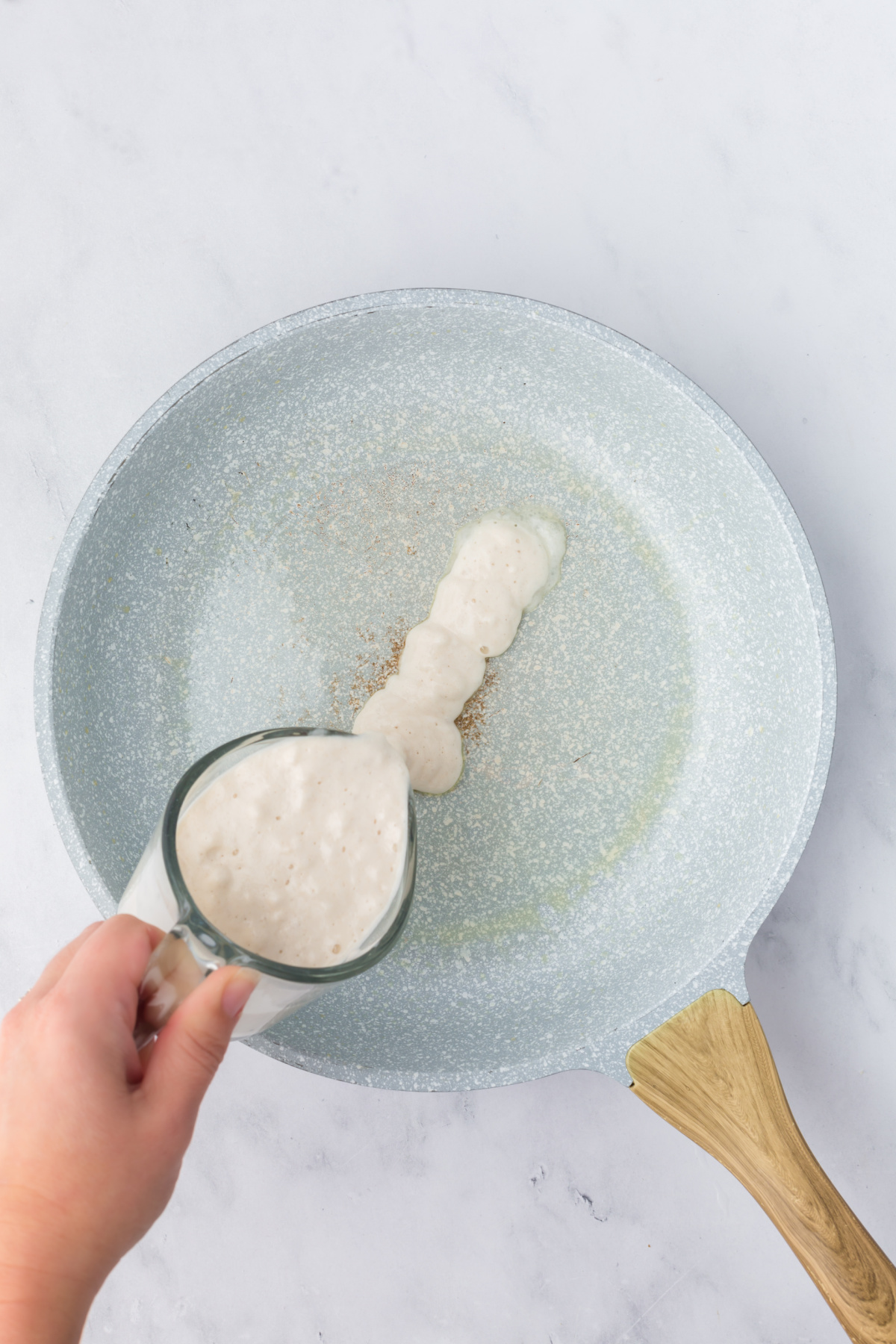 A line of pancake batter poured into a skillet.