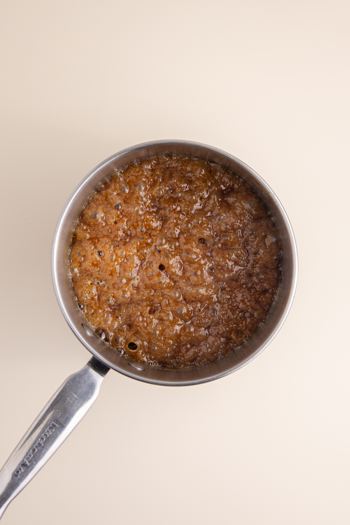 A pot with melted butter and brown sugar boiling in a saucepan,