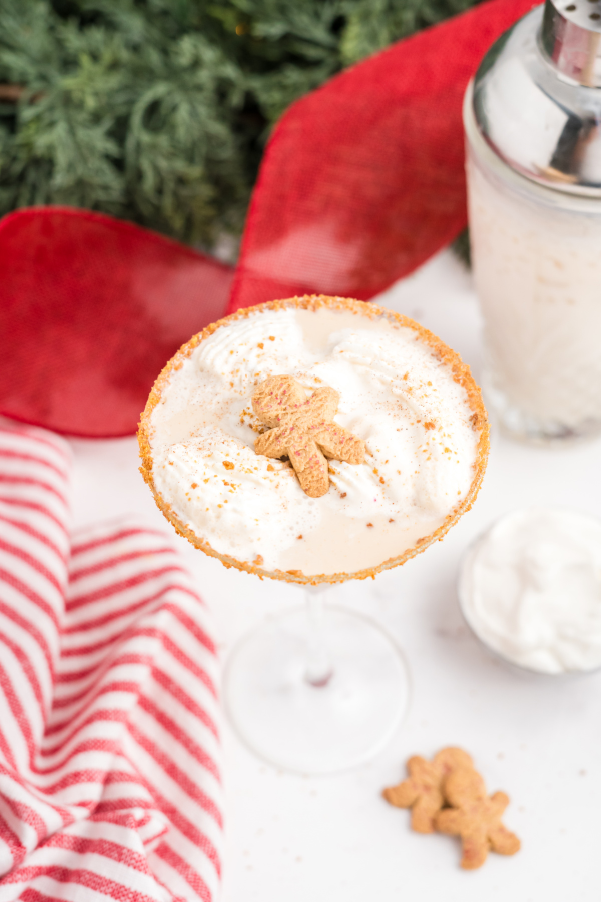 A martini glass filled with liquor and a ginger snap cookie on top.