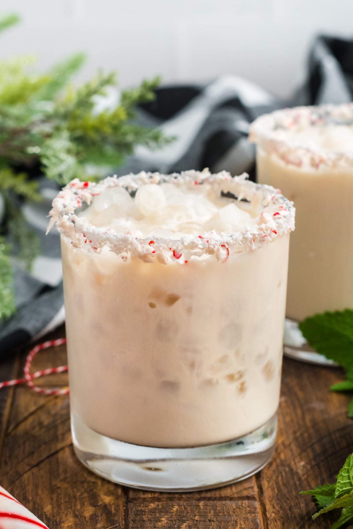 A white russian drink in a glass with ice and peppermint.