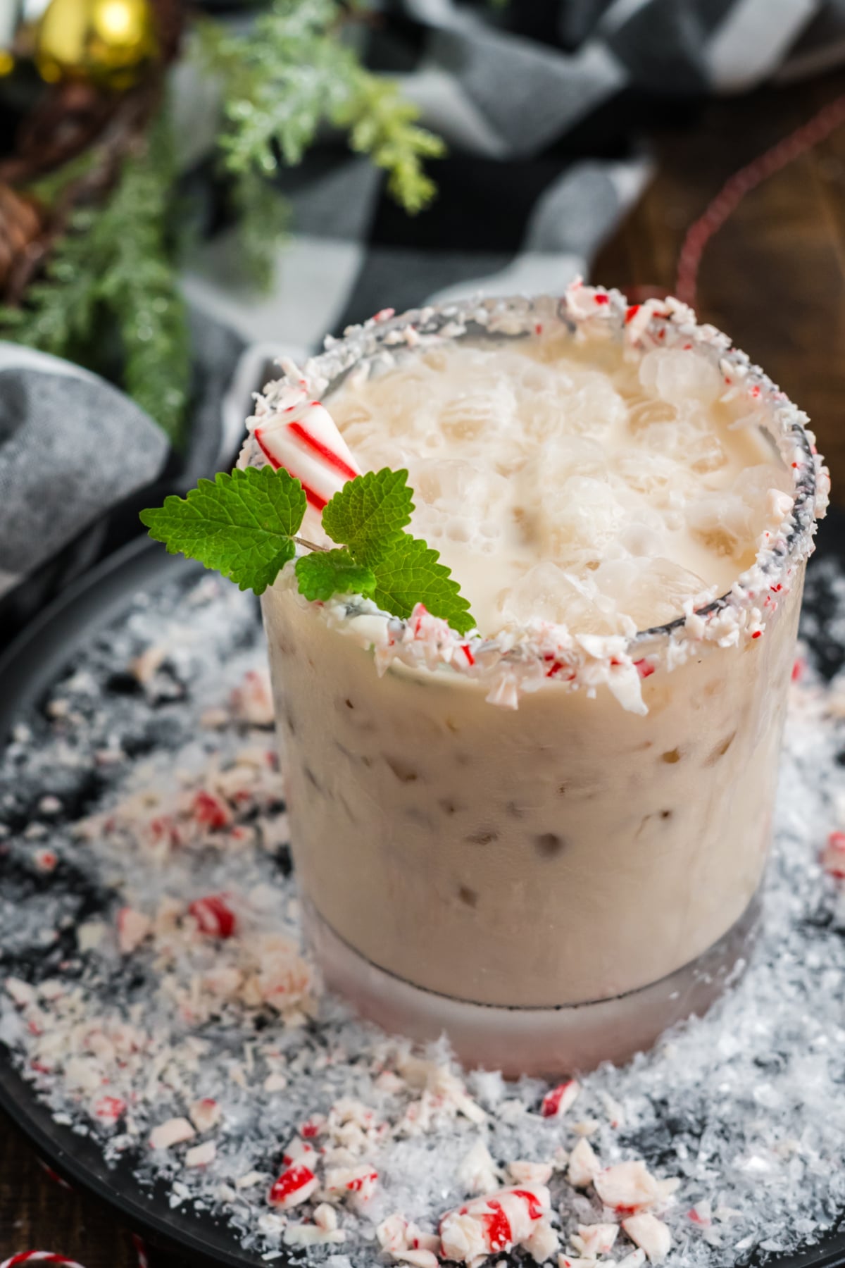 A white russian drink in a glass with ice and peppermint.