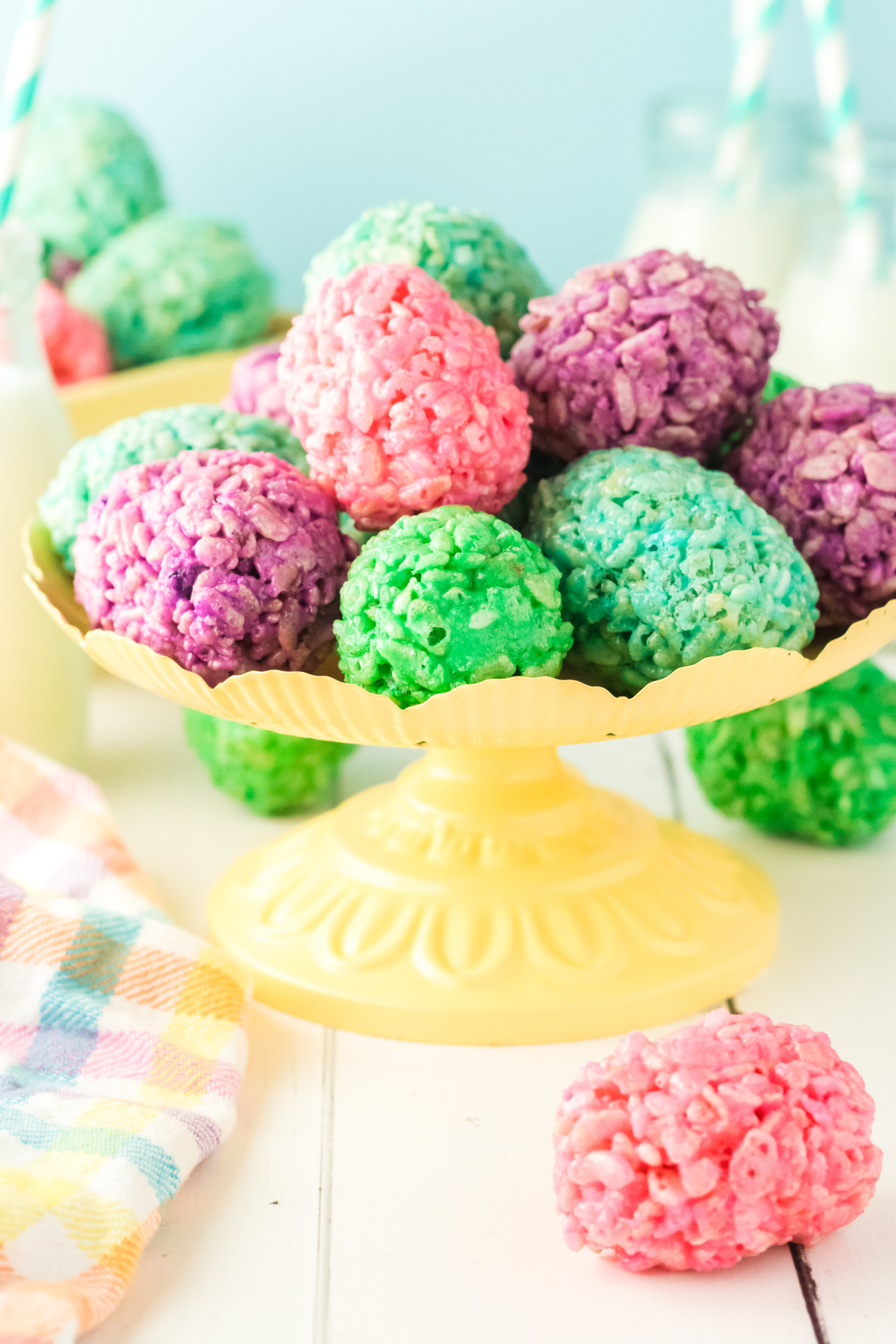 Colorful rice krispie treats in the shape of eggs in a bowl.