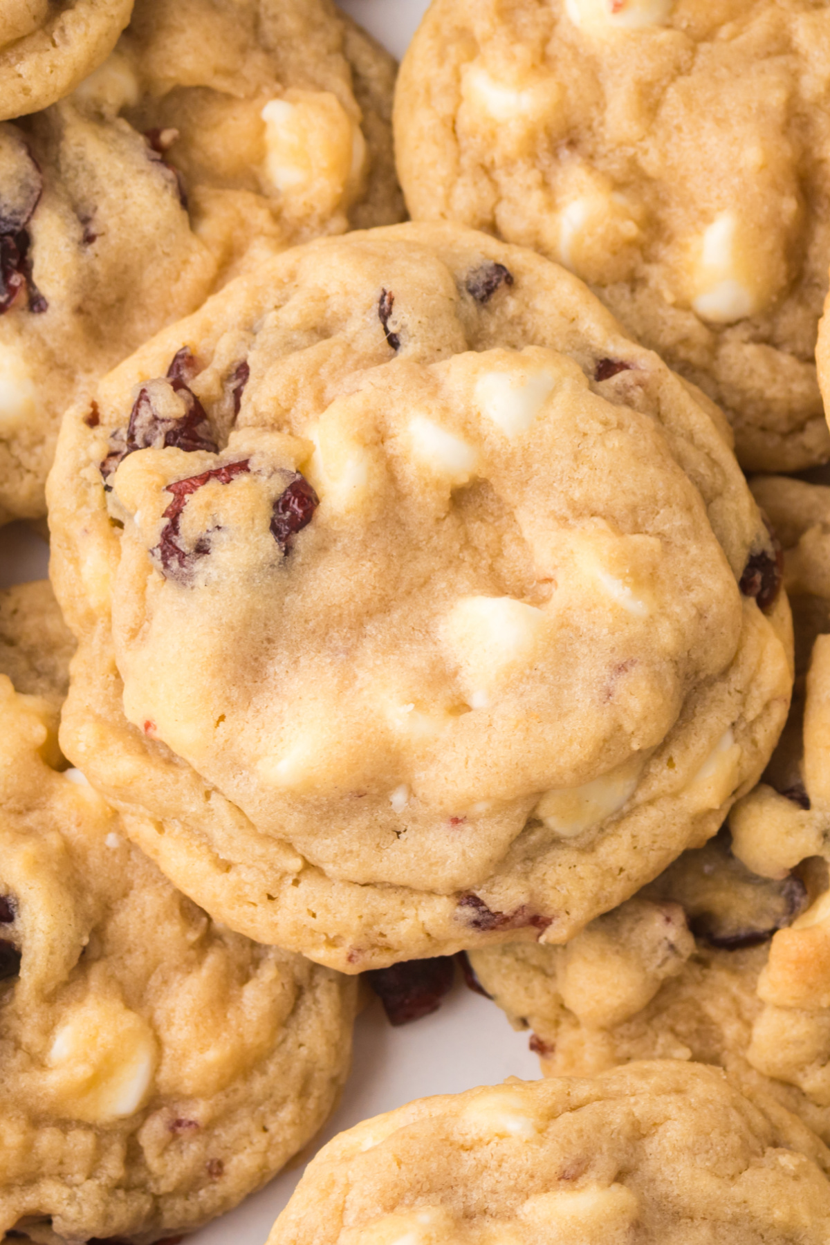 Cookies with white chocolate chips on top of one another.