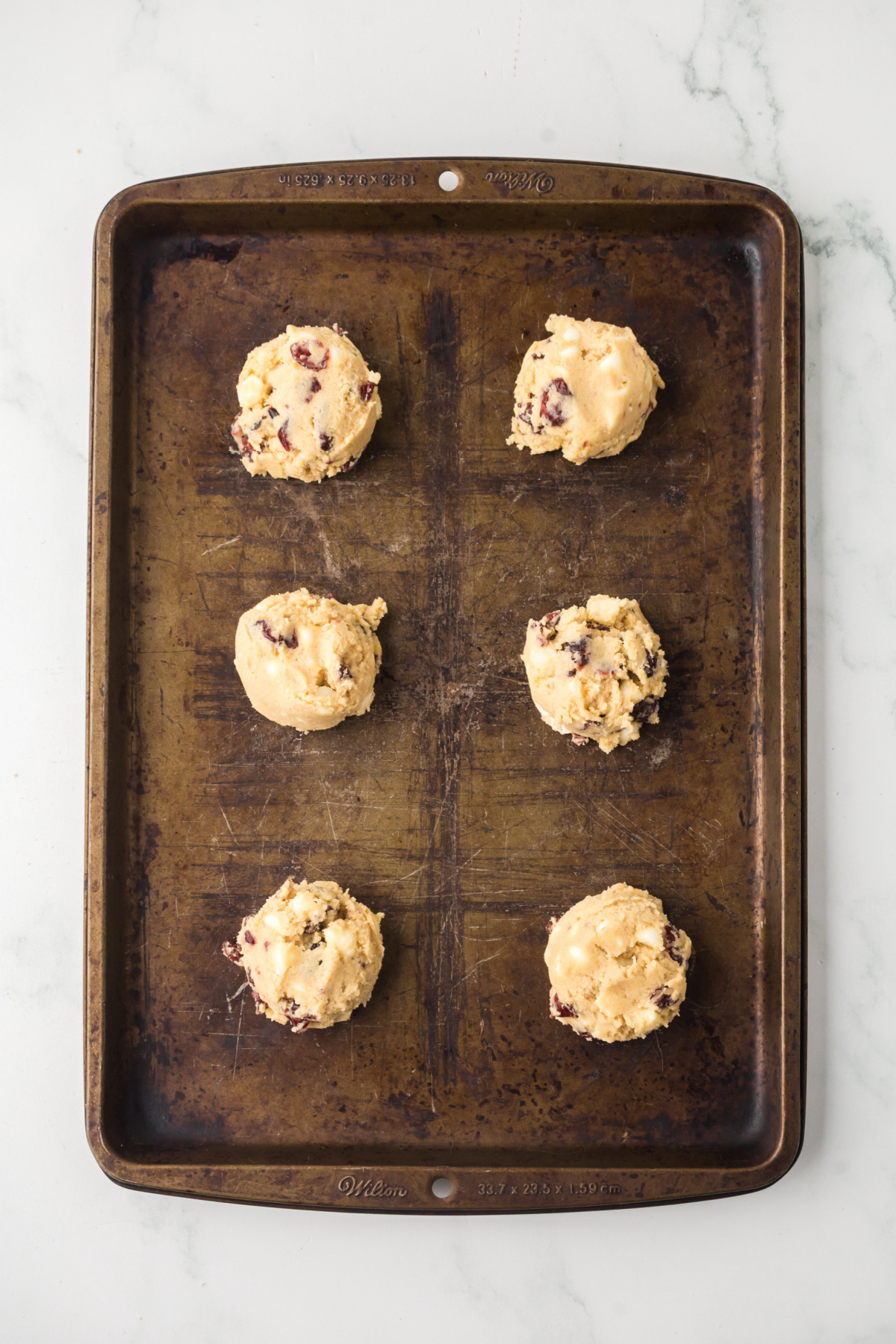 The cookie dough scooped onto the baking sheet.