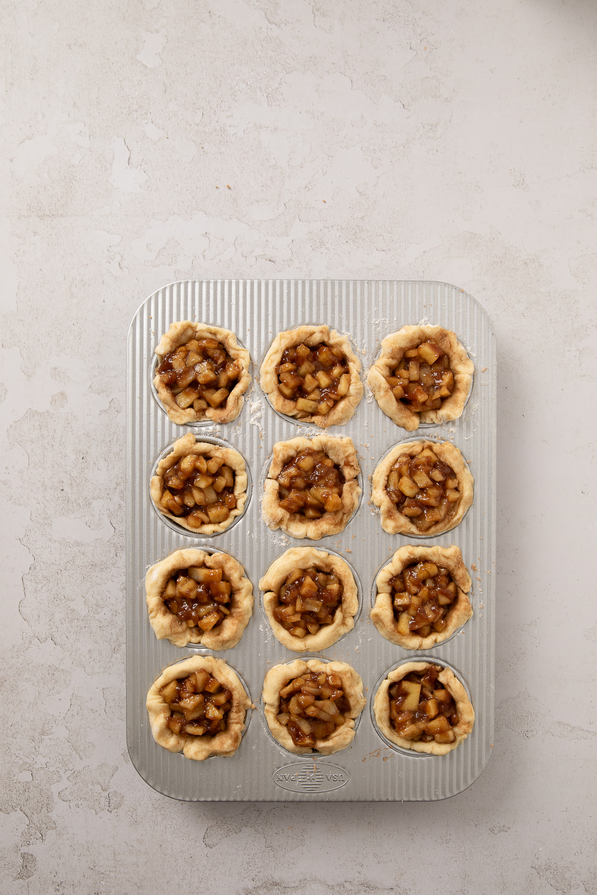 A square into the bottom of each cavity of the muffin tin.