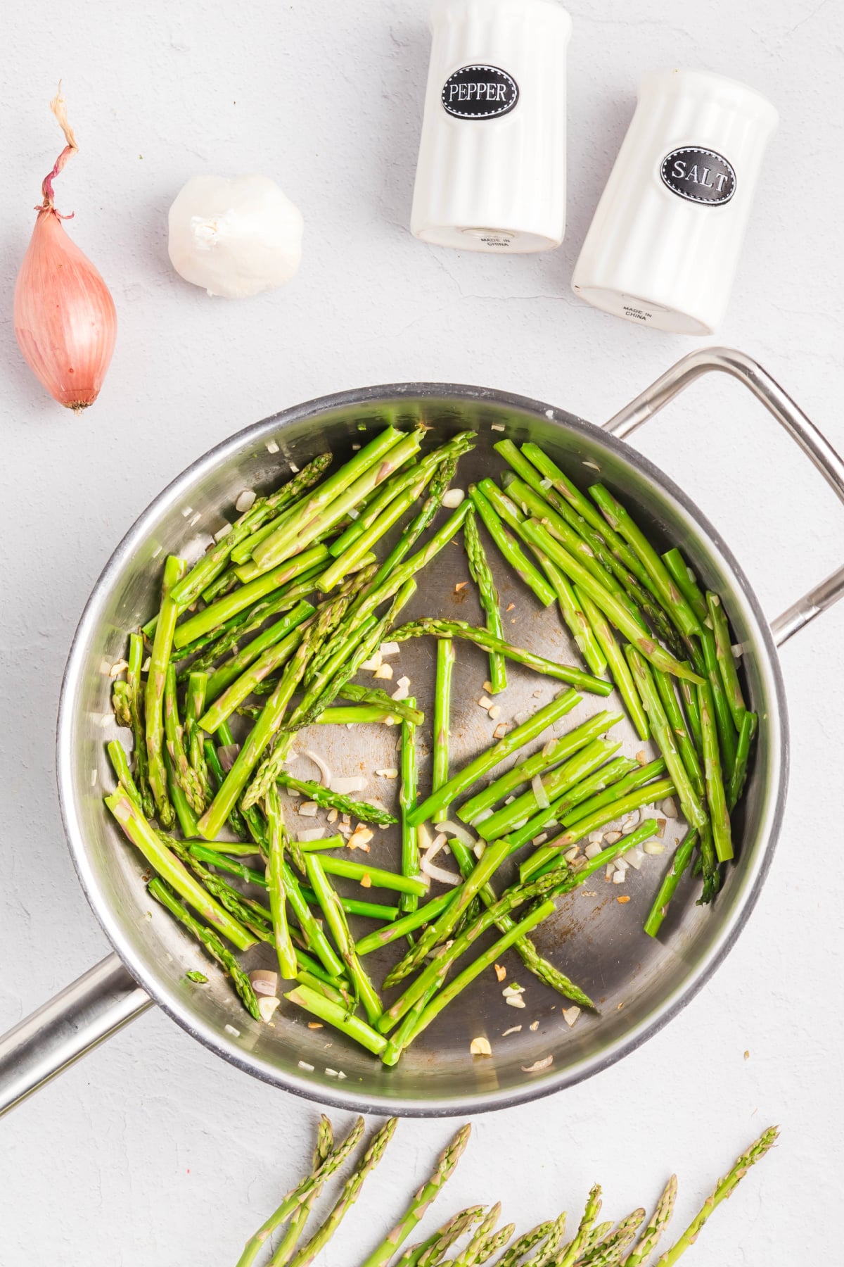 Asparagus, shallots, and garlic added to a skillet.