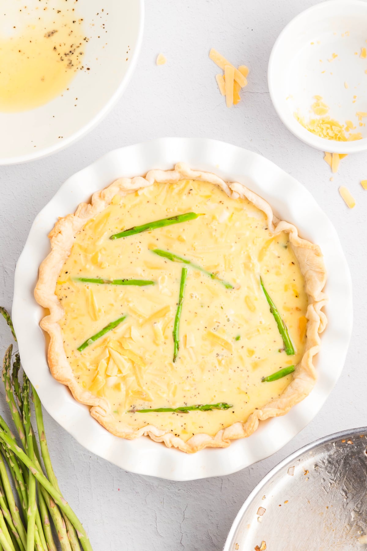 The egg mixture poured into the pie crust and cheese added to the top.