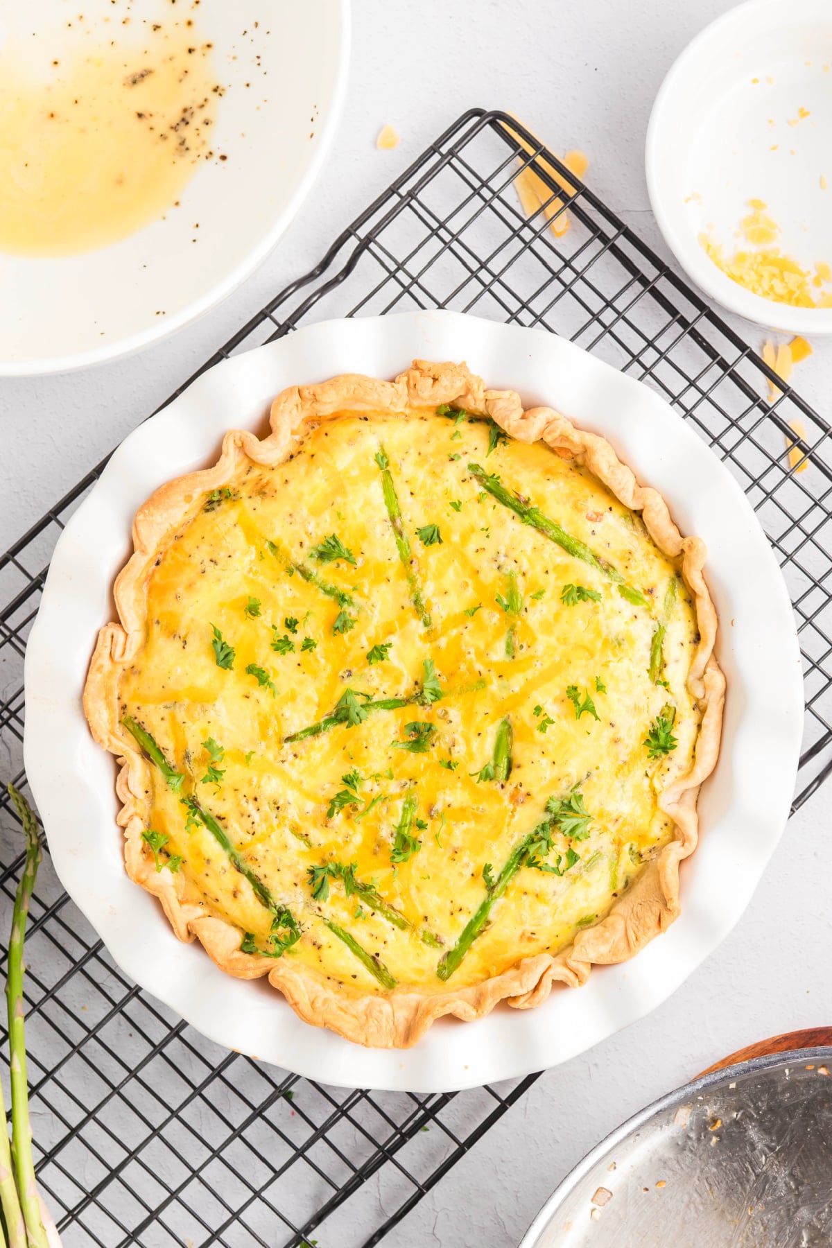 An aspragus quiche cooling on a rack.