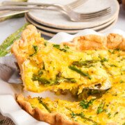 Asparagus quiche being lifted with a spatula.