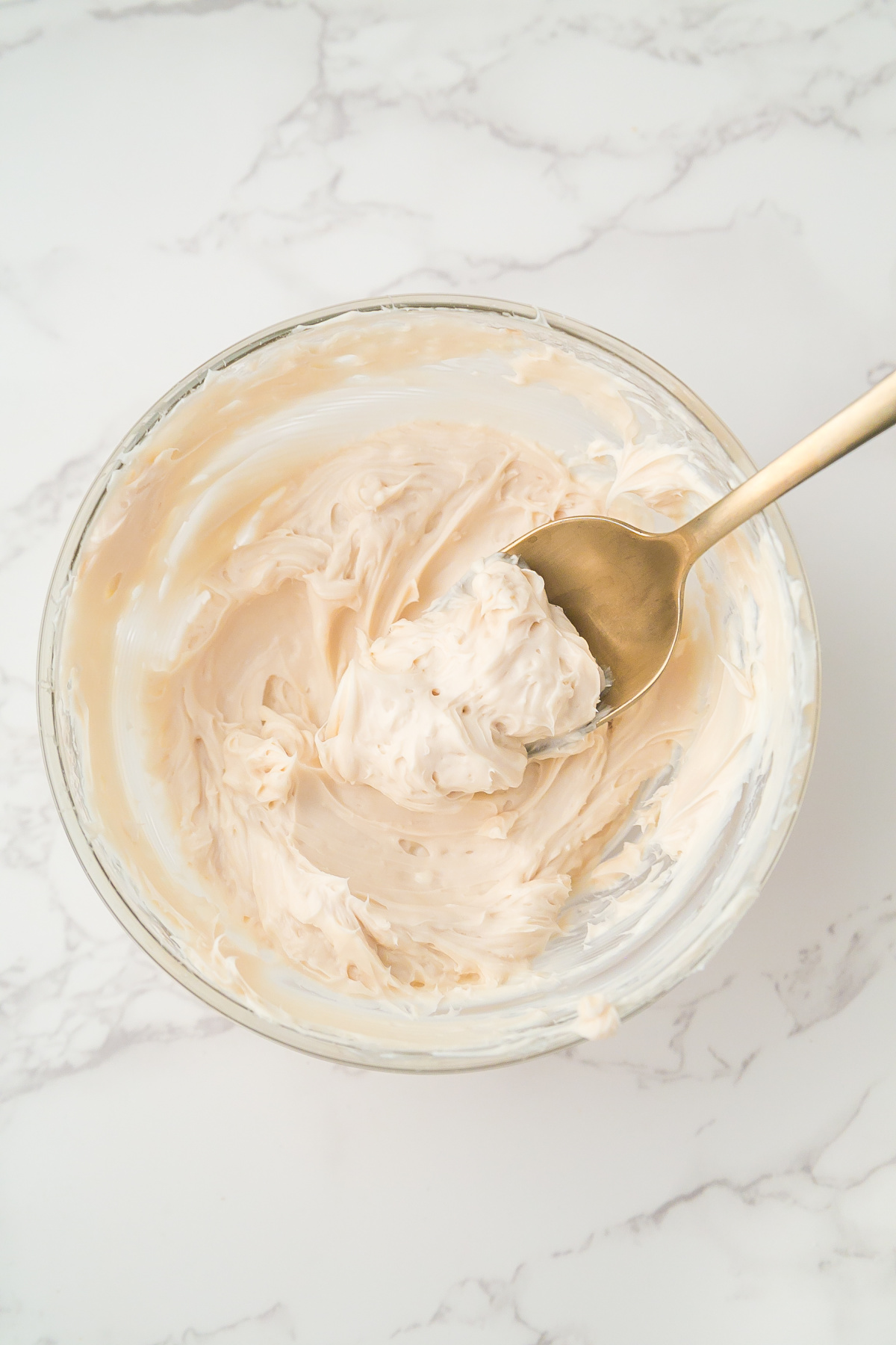 Cream cheese mixture in a bowl with a spoon.