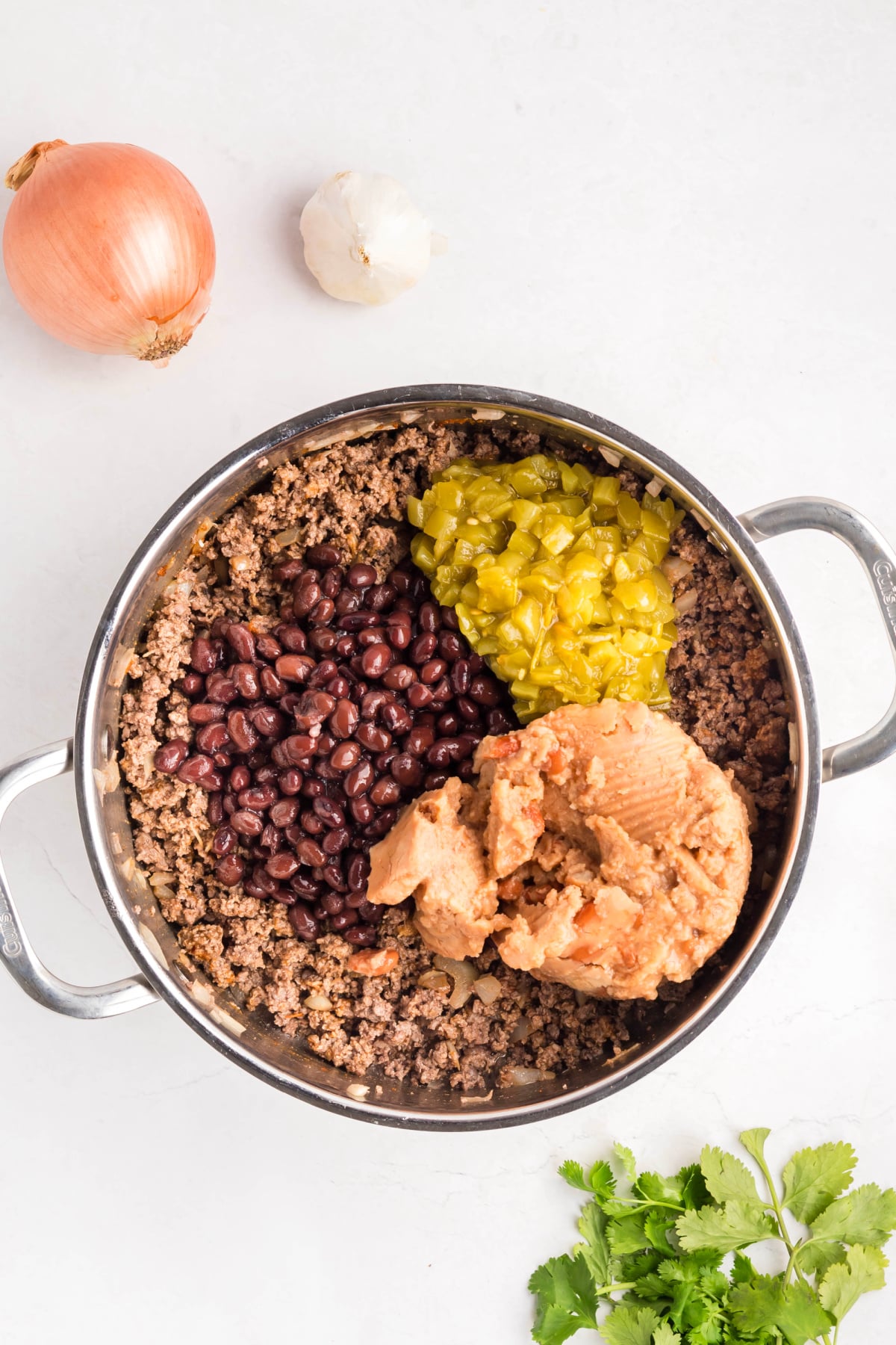 Black beans, refried beans, and chiles added to the skillet.
