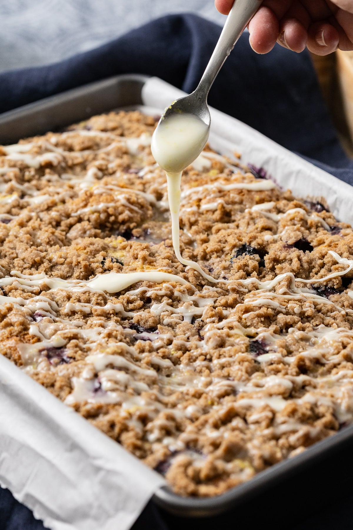 Glaze drizzled over top of the blueberry sour cream cake.