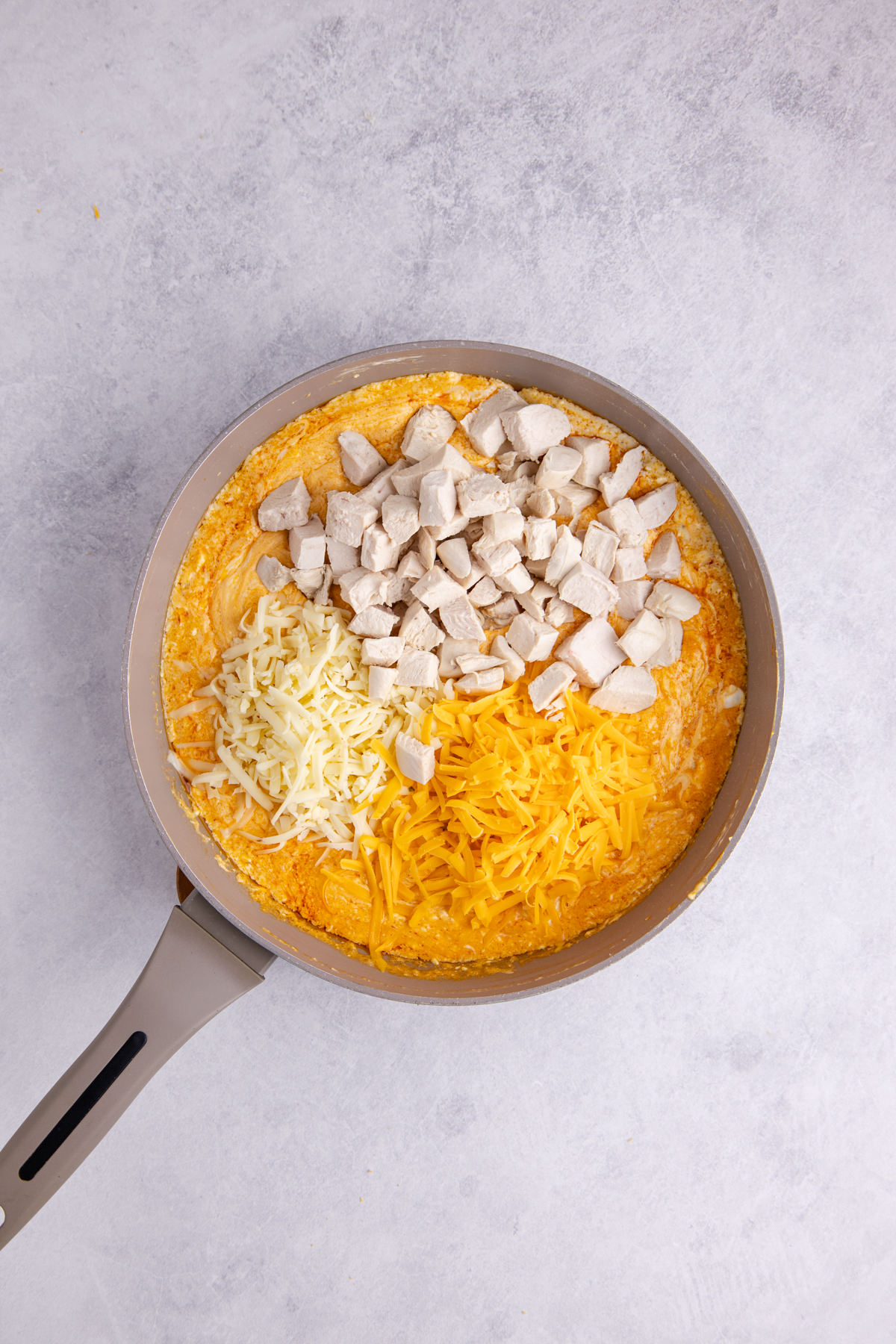 Chicken and shredded cheese added to the sauce pan.