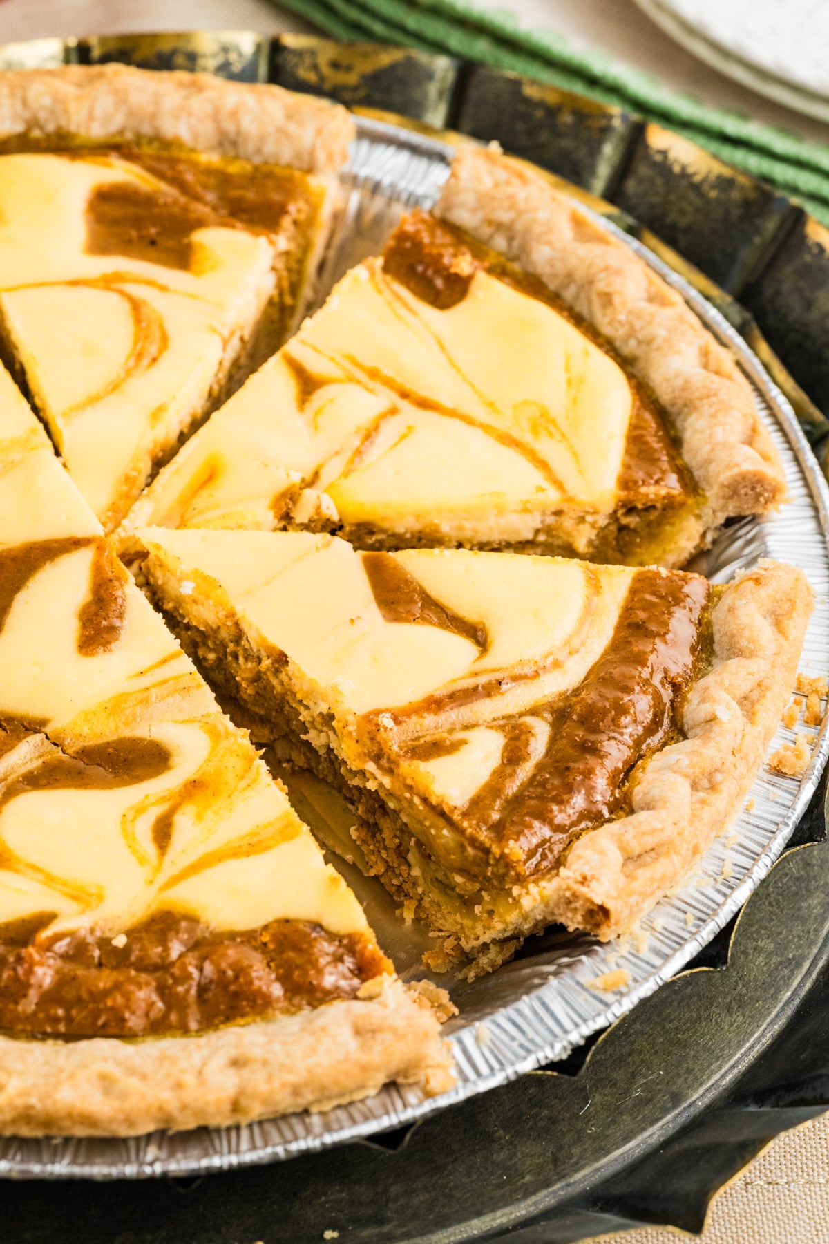 A pie with pumpkin filling and cream cheese on top.