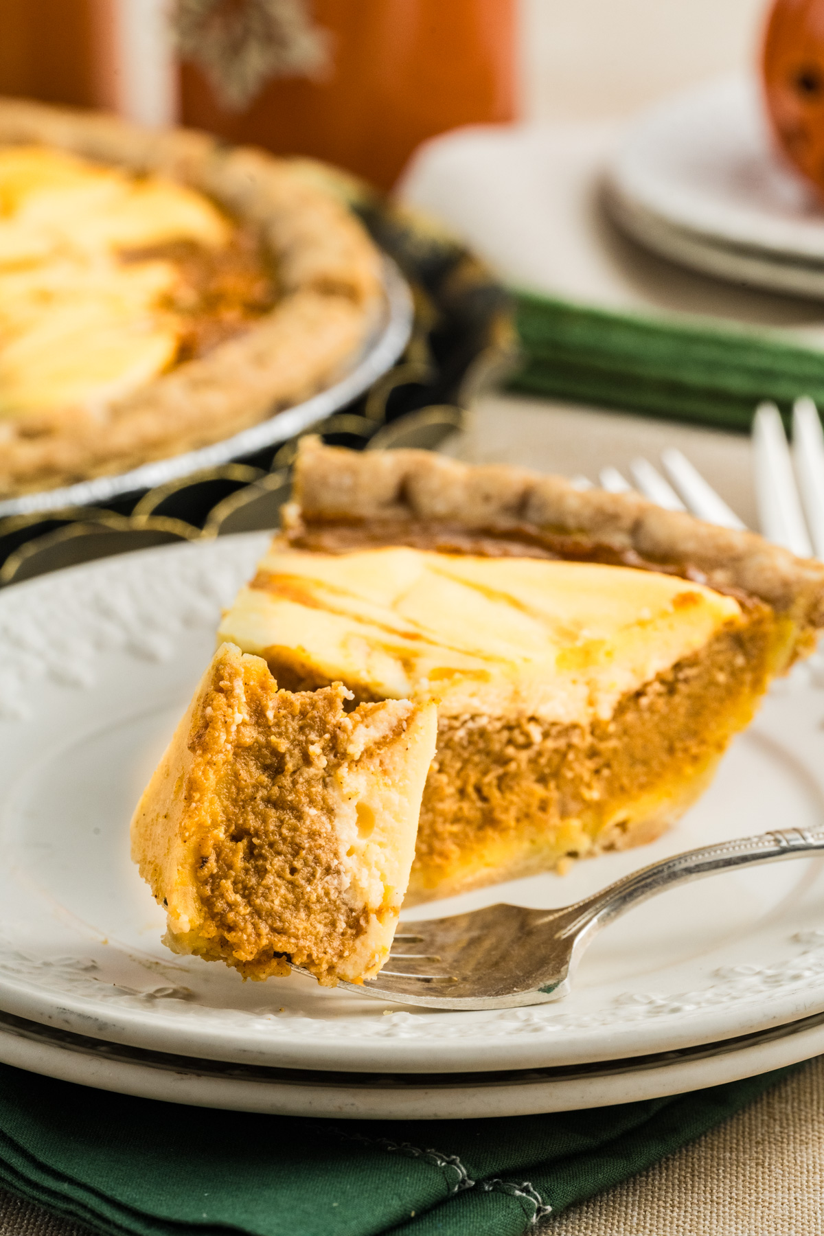 A slice of pie on a plate with a piece taken out of it.