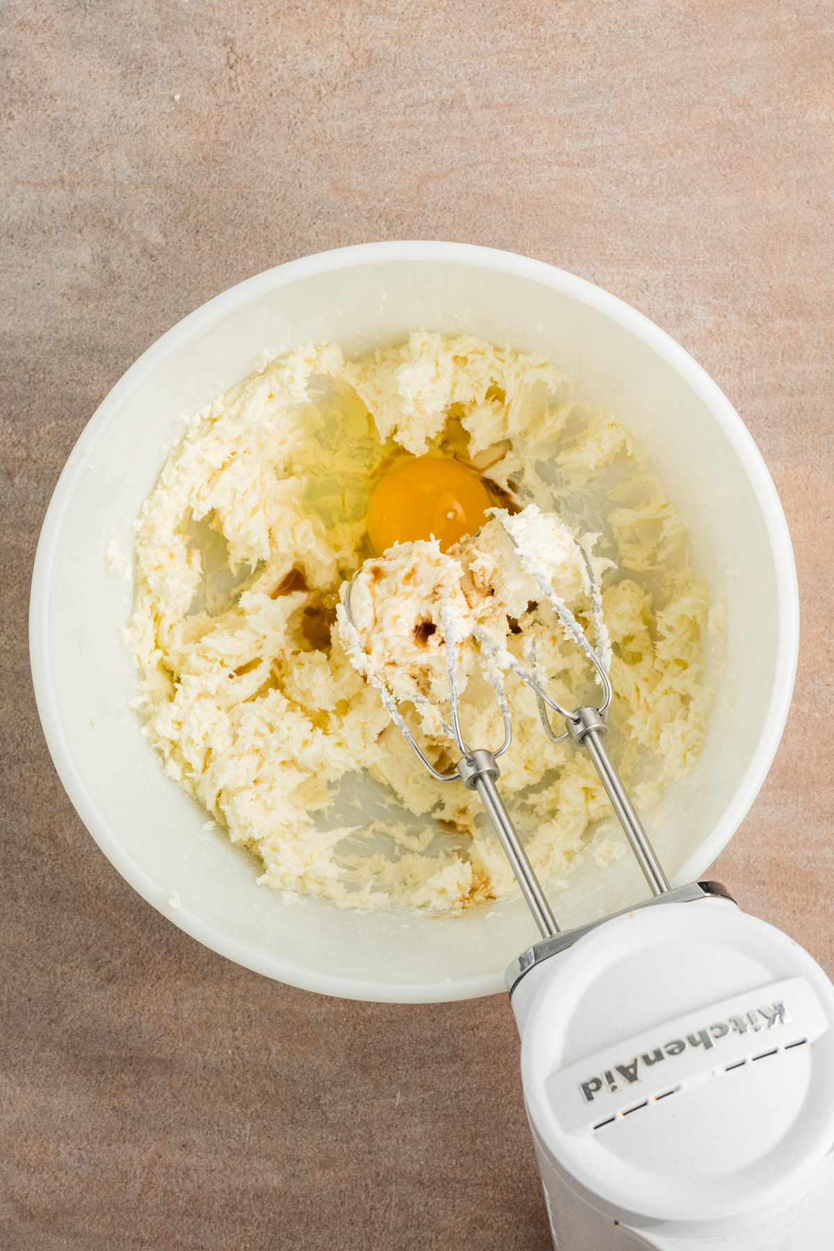 The cream cheese with the eggs, sugar, and vanilla in a bowl and blended with an electric mixer.