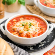 A bowl of crockpot chicken parmesan soup with cheese.