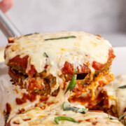 Eggplant casserole being lifted in the air.