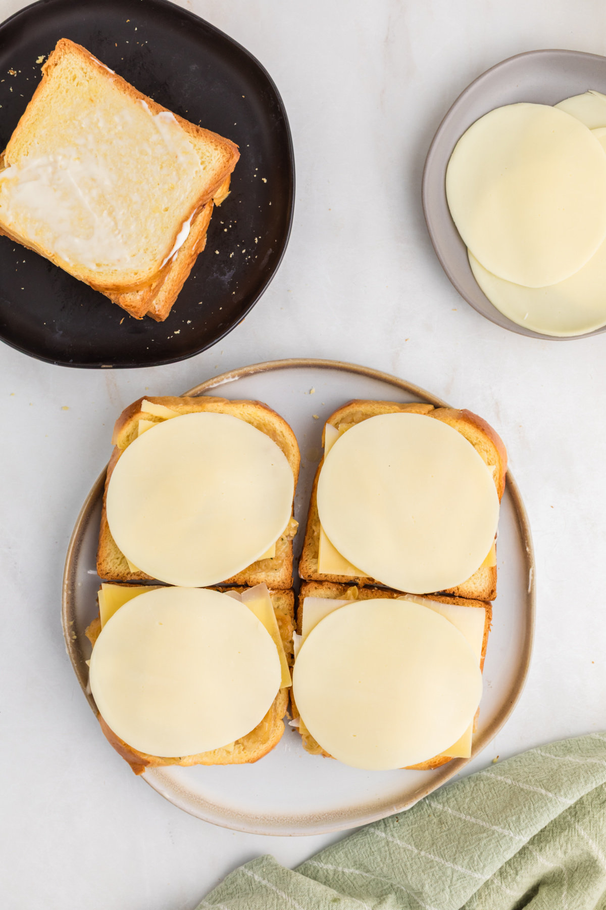 Four grilled cheese sandwiches with slice of provolone to each sandwich.