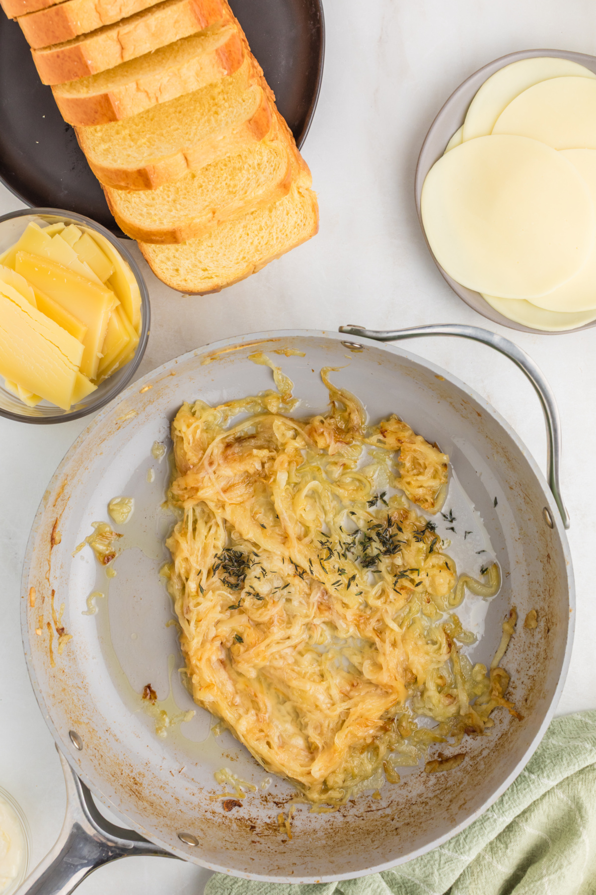 Sauteed onions in a pan with cooking wine and fresh thyme.