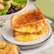 French onion grilled cheese in half on a plate.