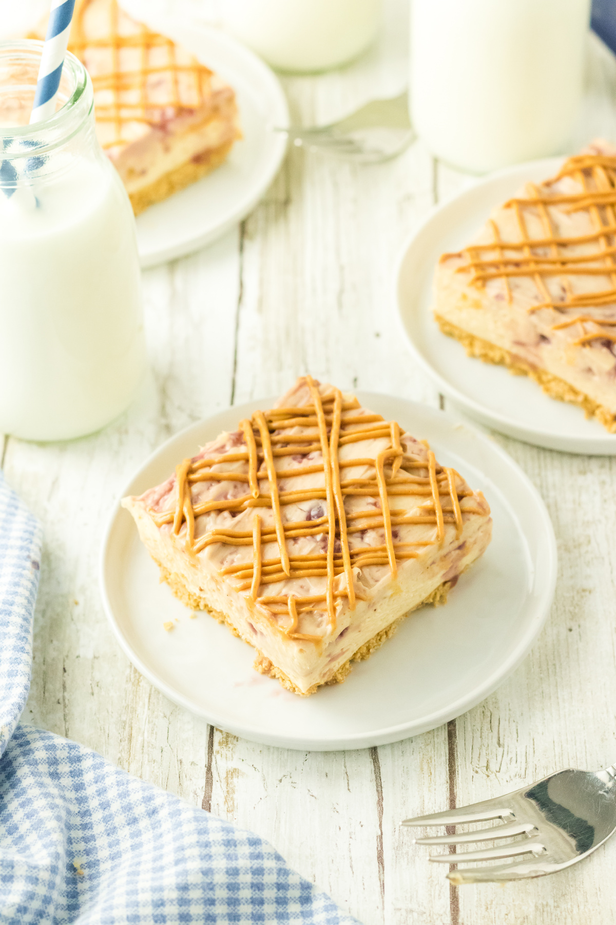 A cheesecake bar with peanut butter drizzled on top.