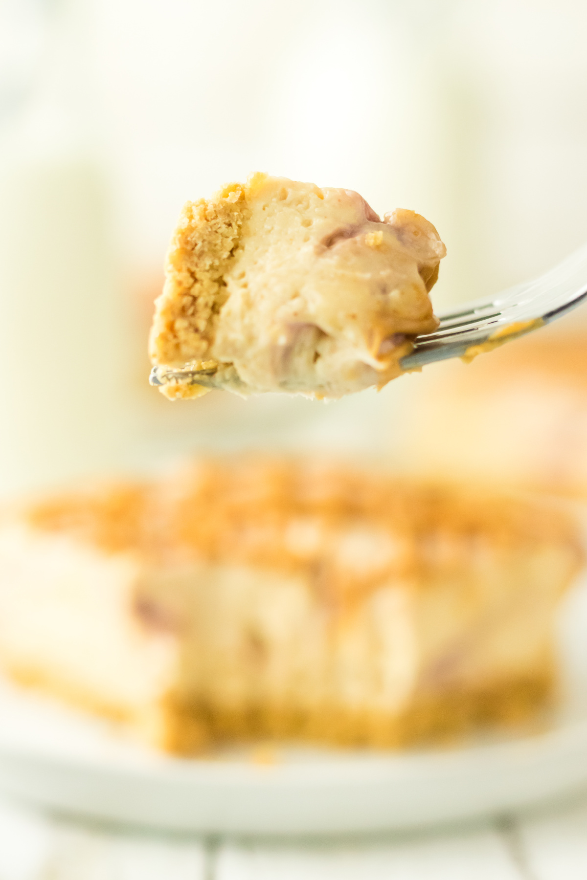 A fork holding up some cheesecake with peanut butter and jelly.