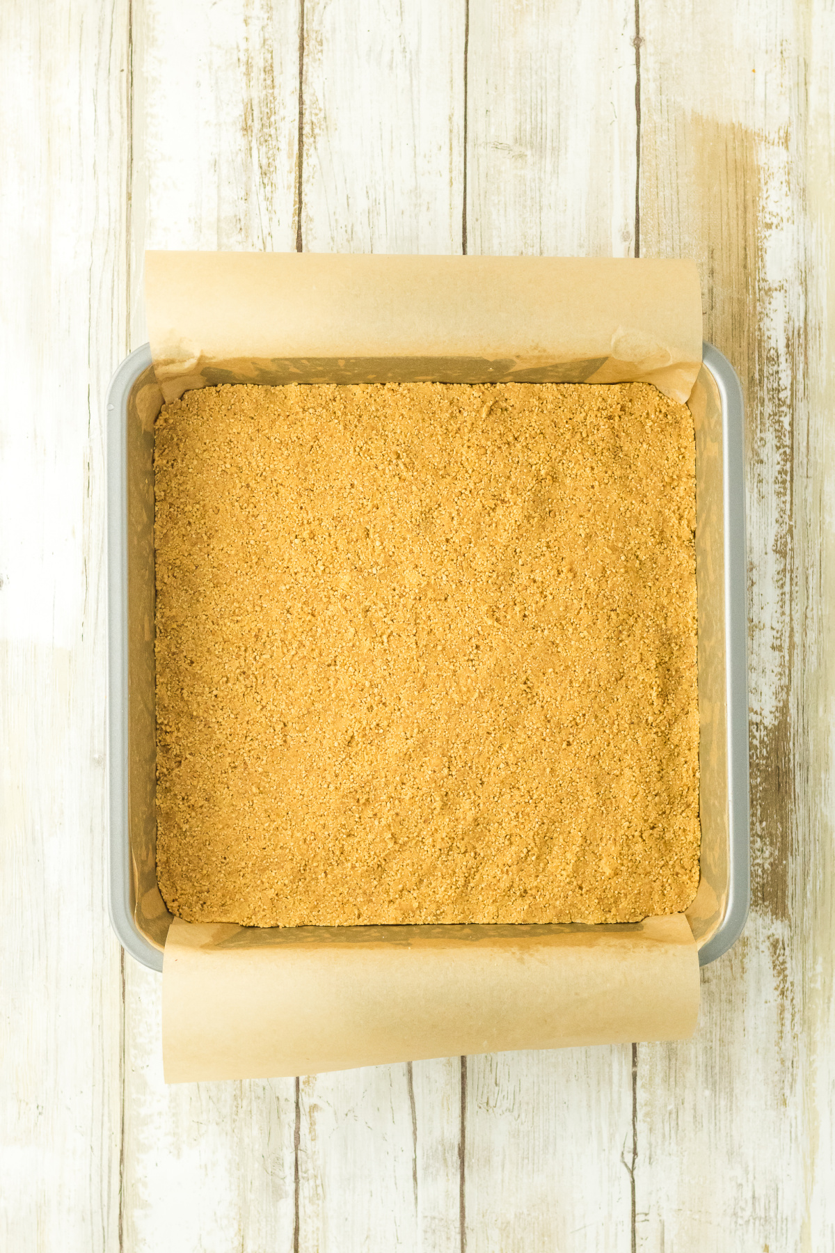 The crust mixture pressed into a baking dish.