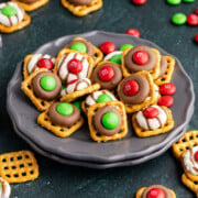 Hershey kiss pretzels on a stack of plates.